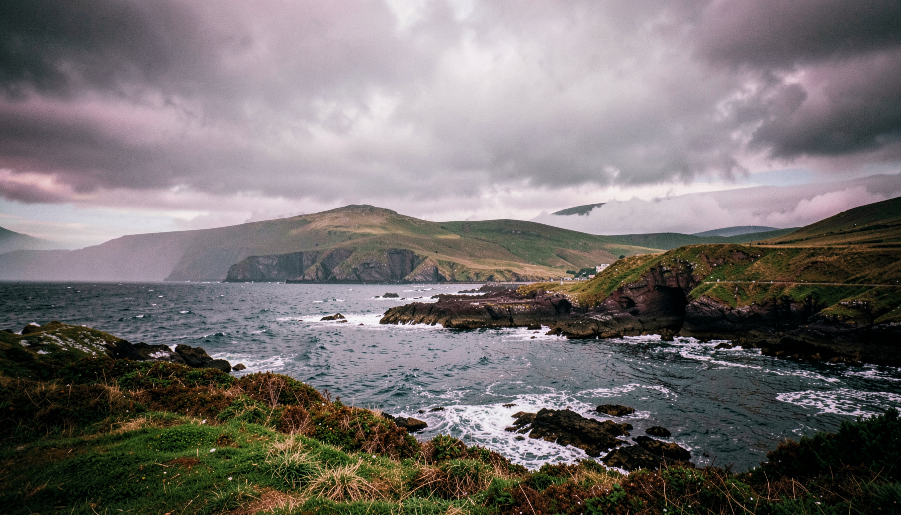 Paisagem costeira irlandesa com céu nublado e tons de verde e cinza, atmosfera de mistério