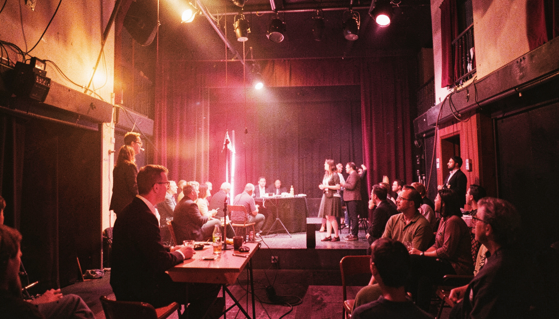 Ambiente teatral dos bastidores com iluminação quente e dourada, atmosfera nostálgica